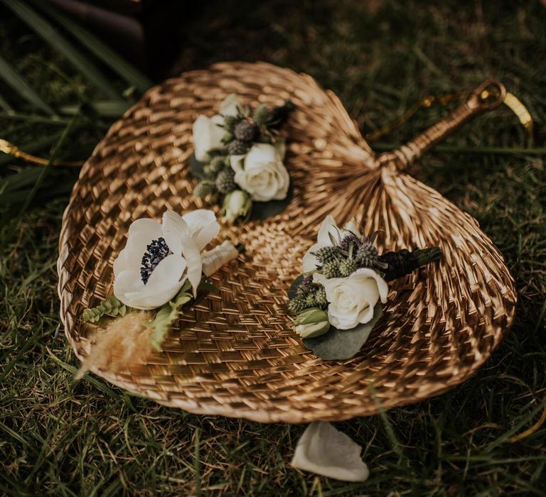 Rattan fans with floral buttonholes