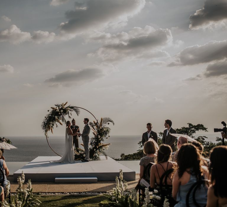 Bride and groom during Thailand wedding ceremony with amazing views and moon gate decor