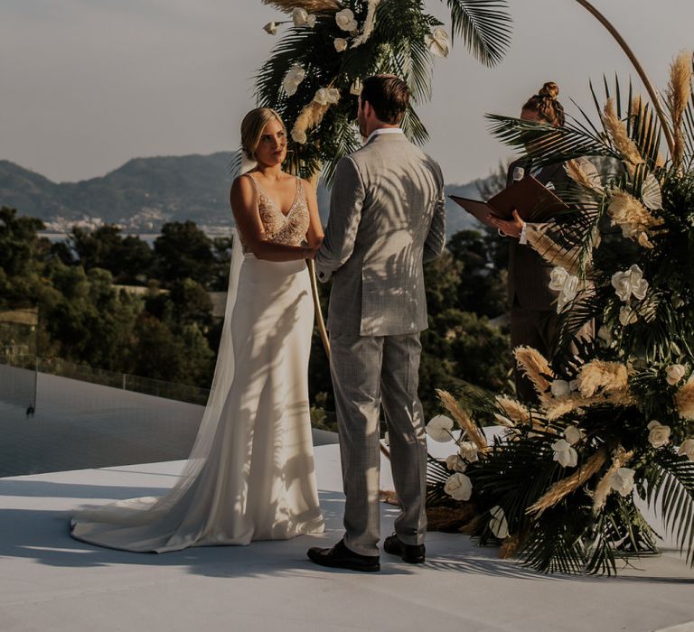 Bride and groom during Thailand wedding ceremony with amazing views and moon gate decor