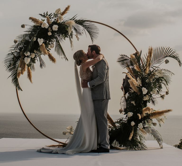 Bride and groom during Thailand wedding ceremony with amazing pampas grass and moon gate decor