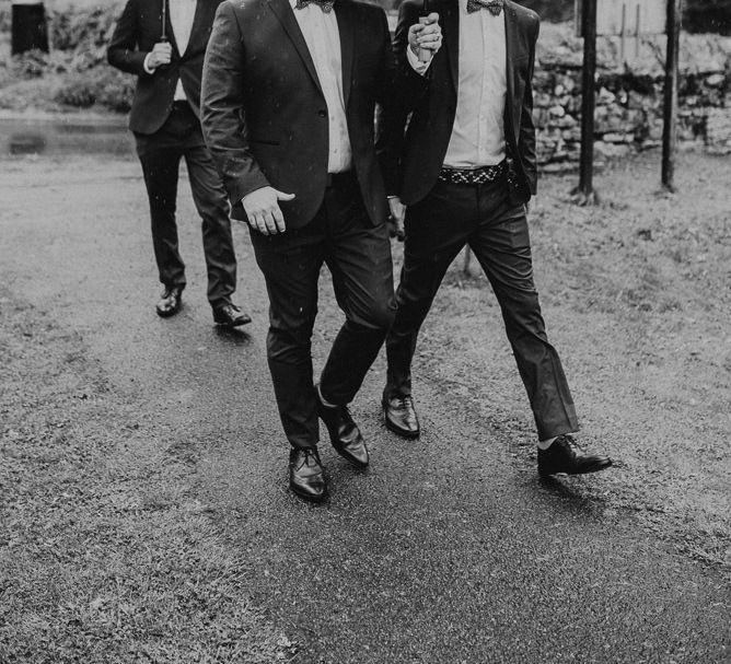 Groomsmen in Suits and Bow Ties Under Umbrellas