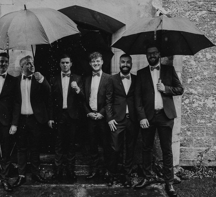 Groomsmen Standing Under Umbrellas