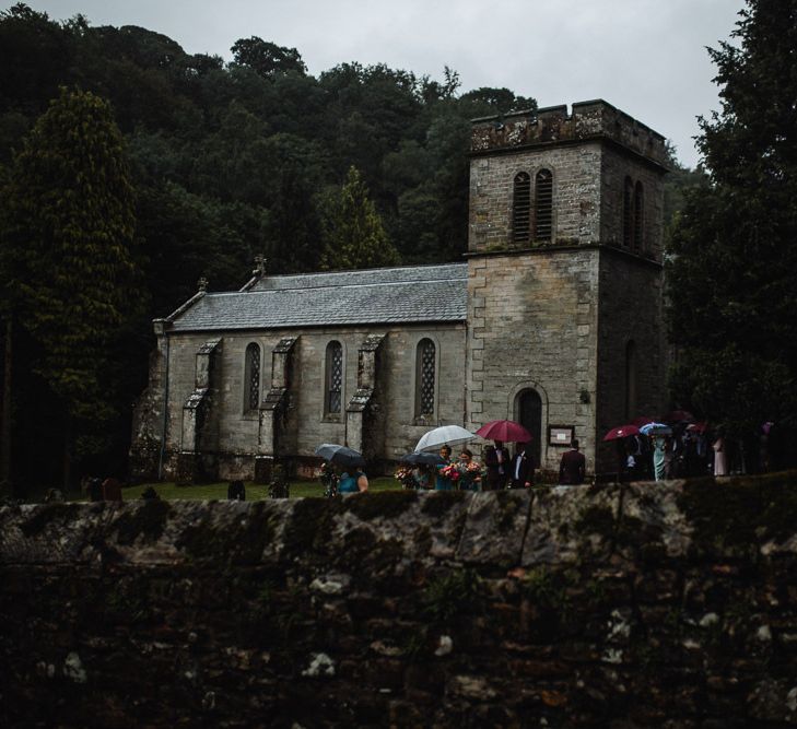 Church Wedding with Guests Standing Under Umbrellas