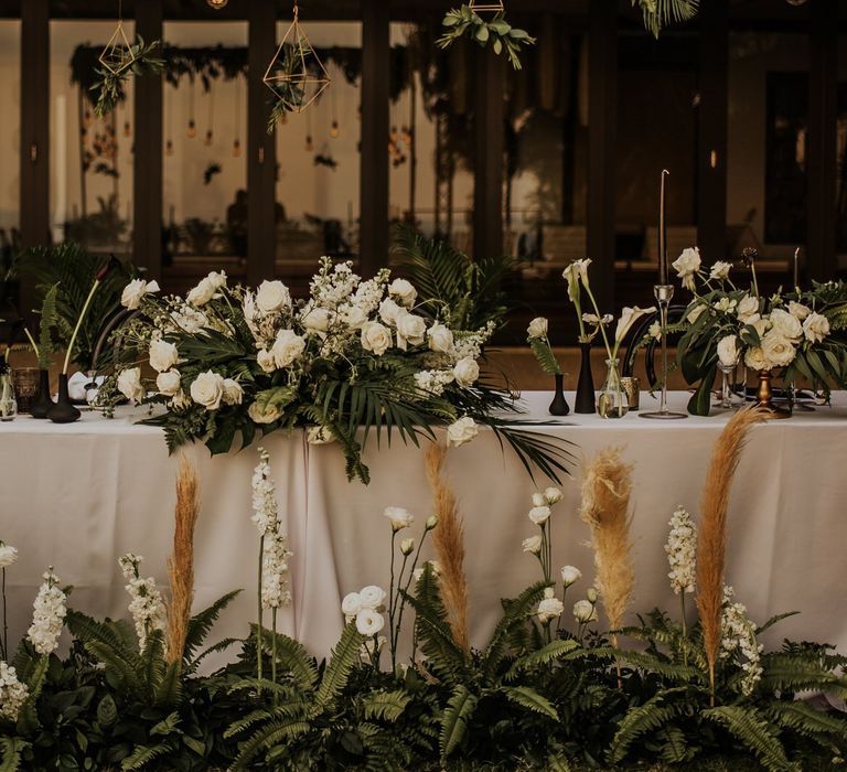 Wedding table decor with white flowers, foliage and pampas grass