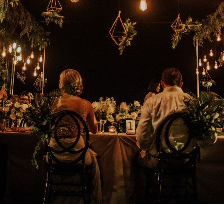 Bride and groom at intimate Thailand wedding with hanging lights and geometric decor