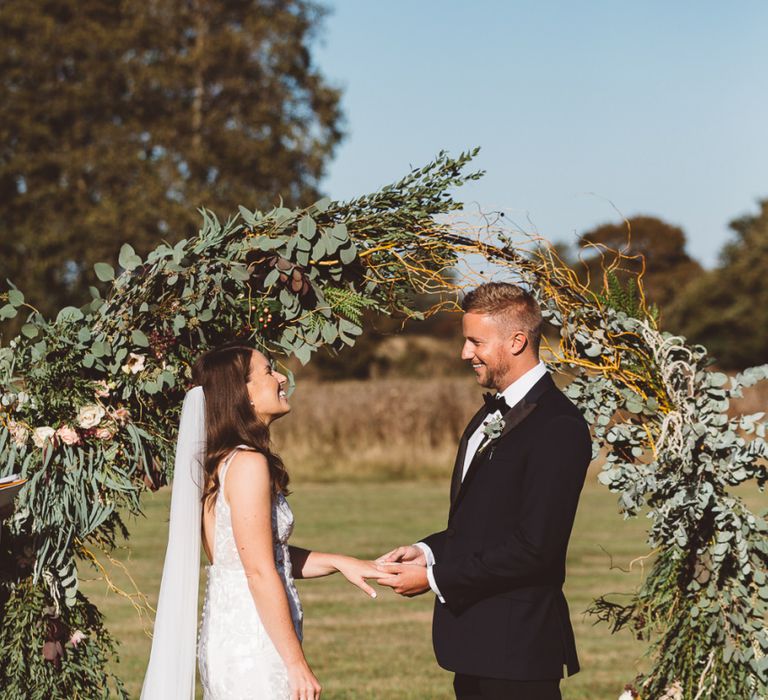 Bride and groom tie the knot at Crouchers Orchards with hoop foliage decor