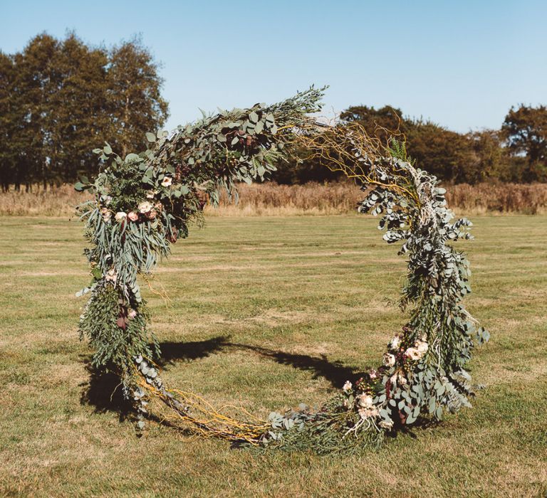 Aisle hoop decor styled with eucalyptus and foliage at Crouchers Orchards for outdoor ceremony