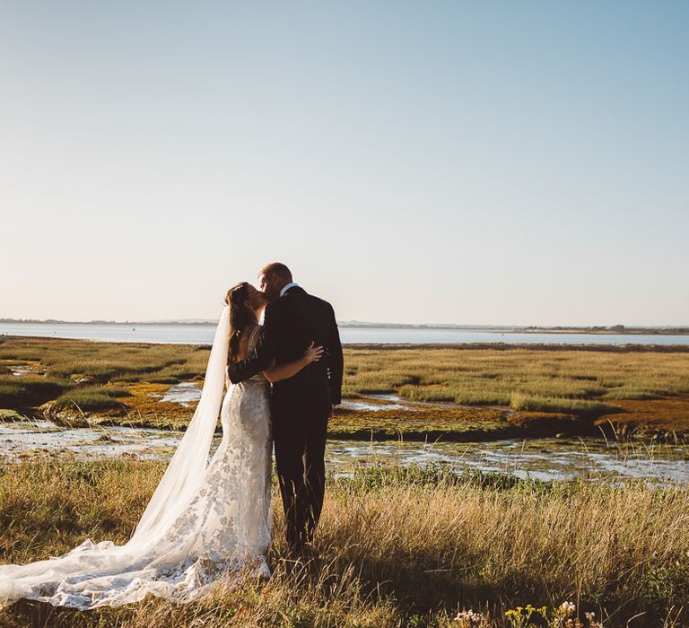 Bride and groom embrace at outdoor wedding