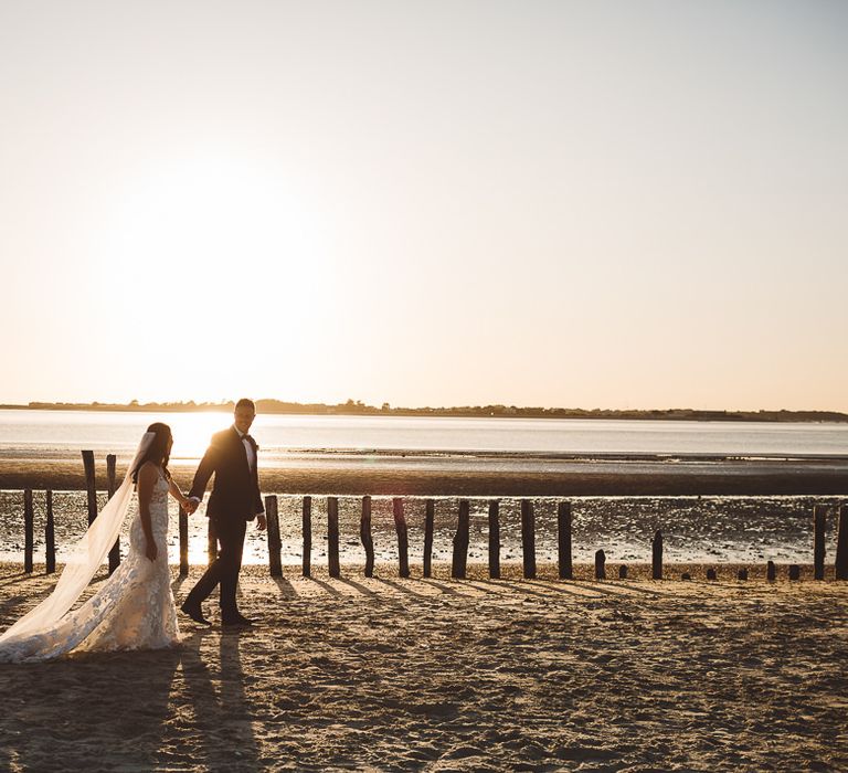 Bride and groom enjoy a beach shoot together at golden hour