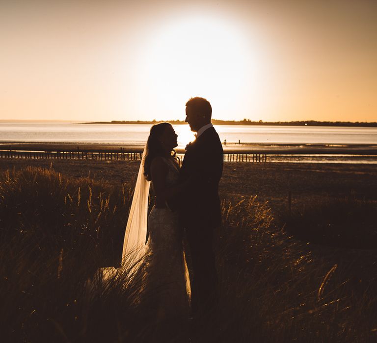 Bride and groom enjoy a beach shoot together at golden hour