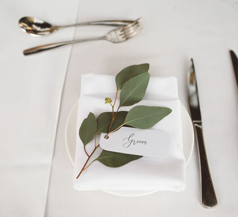 Place settings for intimate wedding styled with eucalyptus