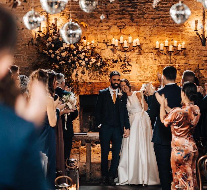 Newlywed bride and groom at October wedding with glitter ball decor