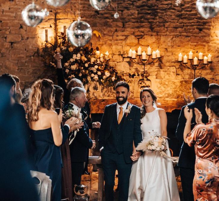 Newlywed bride and groom at October wedding with glitter ball decor