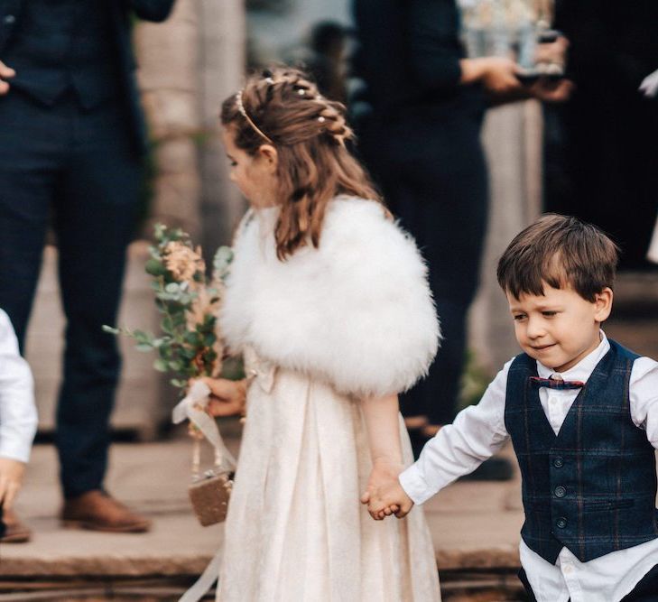 Flower girl with faux fur bolero jacket at October wedding