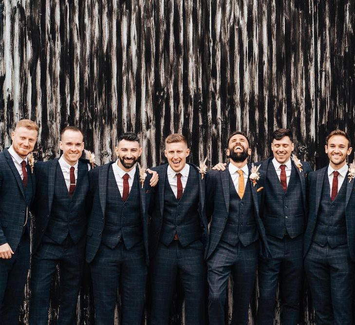 Groomsmen in matching check suits with burgundy ties