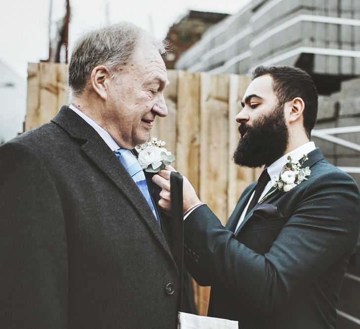 Groom Pinning Buttonhole on Father of the Bride