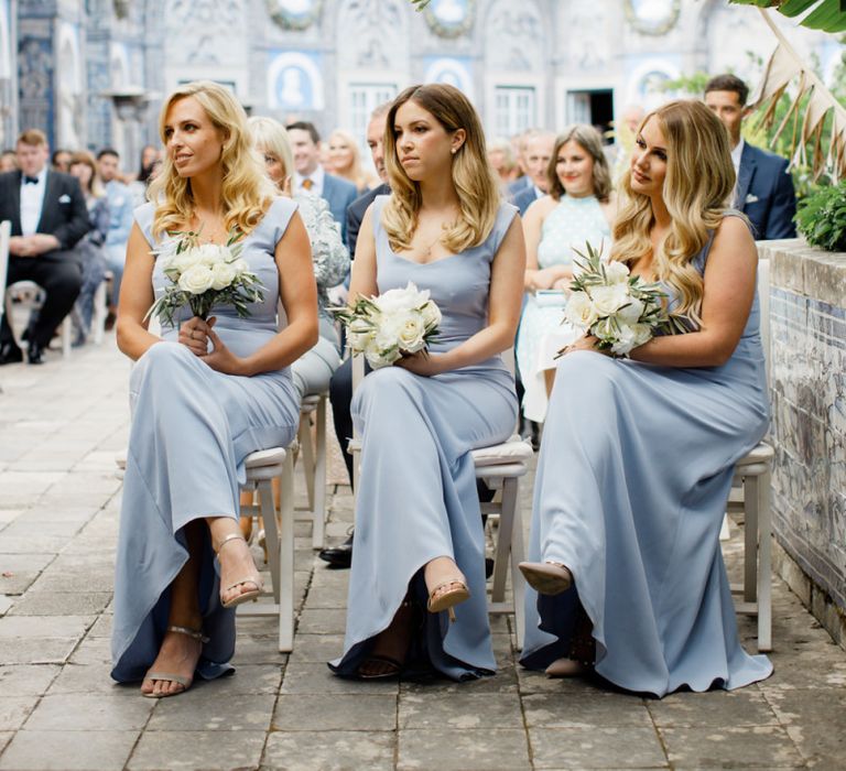 Bridesmaids in Pale Blue Dresses with Wavy Hair and White Bouquets