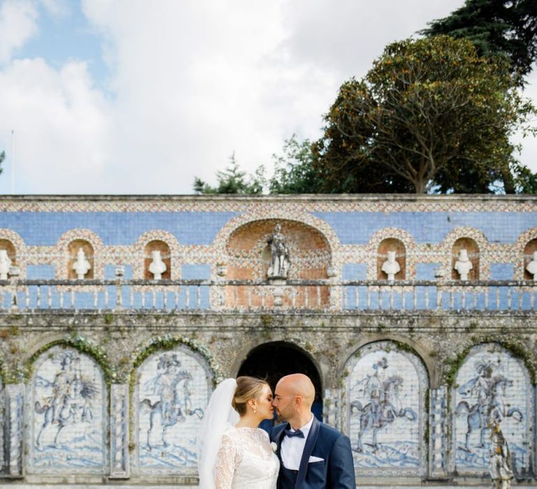 Bride in Lace Wedding Dress and Groom in Navy Blue Tuxedo