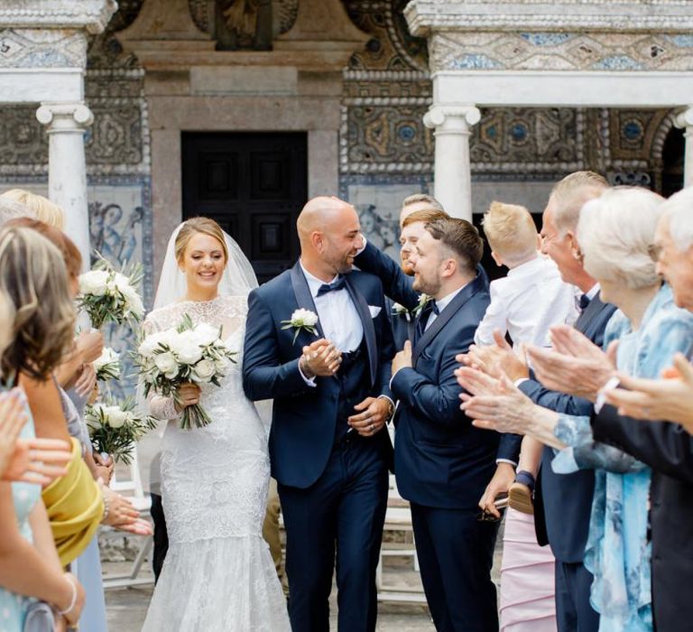 Bride in Fishtail Wedding Dress and Groom in Navy Tuxedo Walking up the Aisle as Husband and Wife