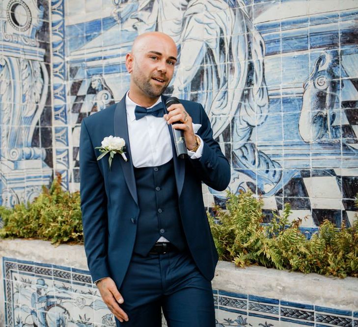 Groom in Navy Suit with Horseshoe Waistcoat and Bow Tie