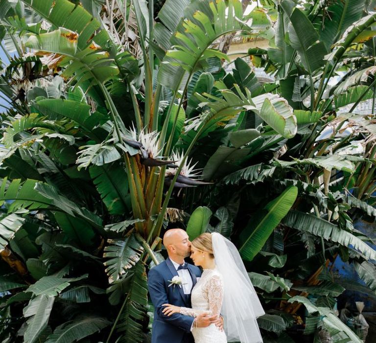 Bride in Yolan Cris Wedding Dress with Long Sleeves and Groom in Navy Suit