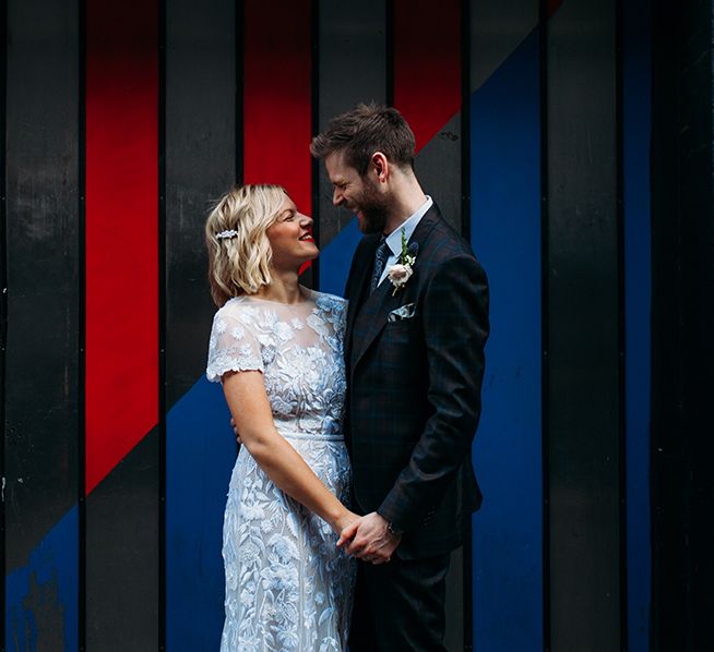 Bride in Lace Hermione De Paula Wedding Dress and Groom in Ted Baker Suit  Embracing