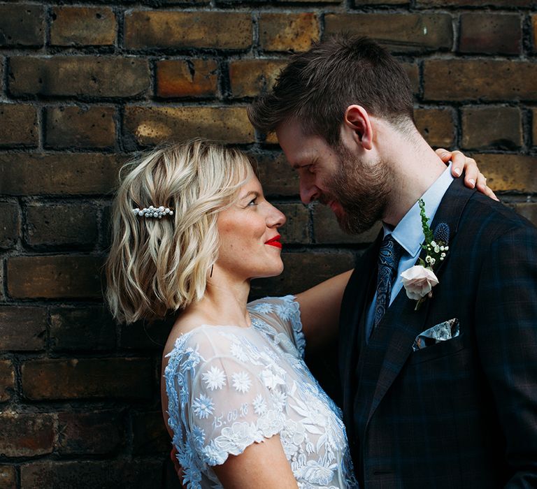 Bride in Lace Hermione De Paula Wedding Dress with Bob Hair &amp; Pearl Slide  and Groom in Ted Baker Embracing