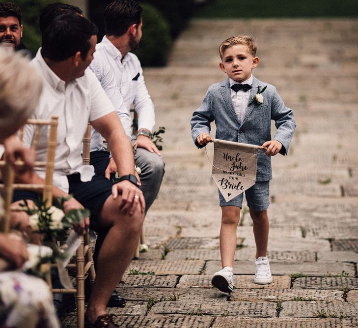 Page Boys in Shorts &amp; Bow Tie with Flag Sign | Stylish Tuscan Wedding at Vignamaggio Planned by The Wedding Boutique Italy | Samuel Docker Photography | Paul Vann Films