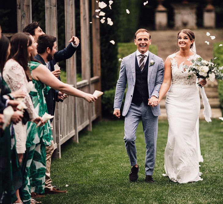 Confetti Moment | Bride in Pronovias Wedding Dress | Groom in Light Blue Suit Supply Suit | Stylish Tuscan Wedding at Vignamaggio Planned by The Wedding Boutique Italy | Samuel Docker Photography | Paul Vann Films