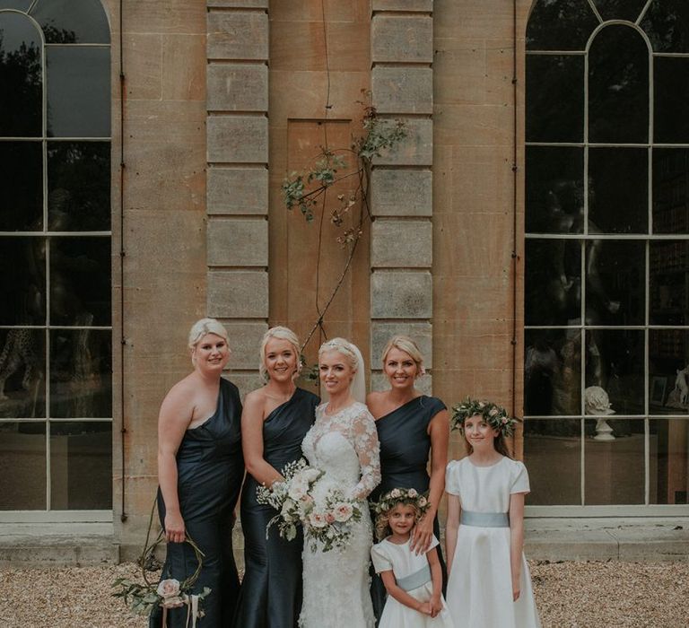 Bride in Suzanne Neville wedding dress with bridal party in dark grey bridesmaid dresses