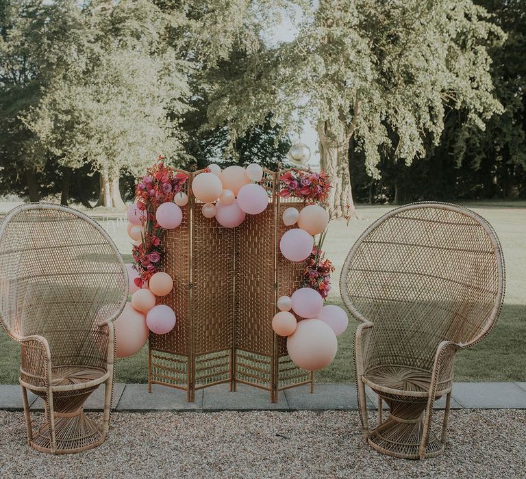 Pink wedding balloons and peacock chair decor