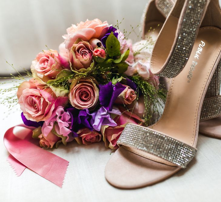 Silver wedding shoes and bright bridal bouquet