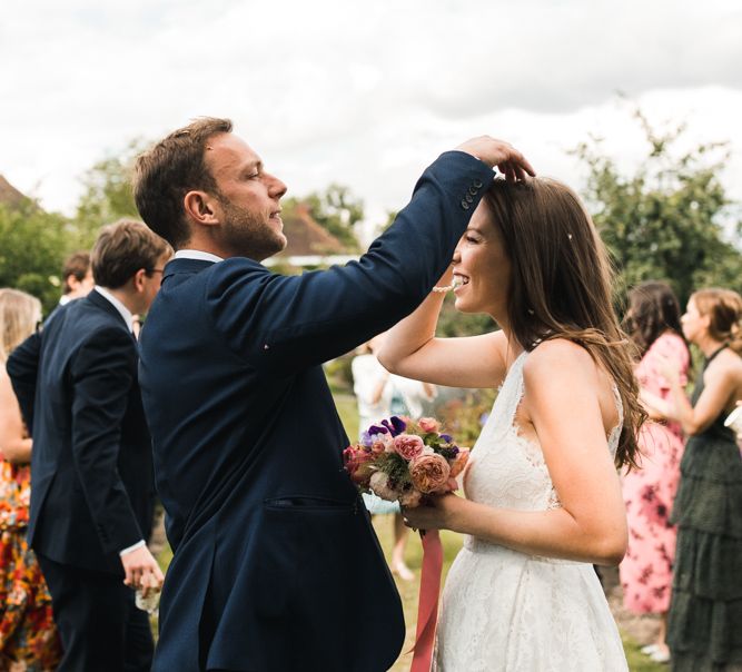 Groom picking confetti out of his brides hair