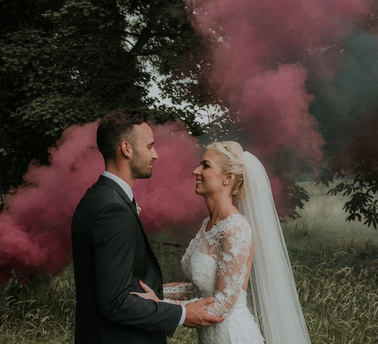 Colourful smoke for groom and bride in Suzanne Neville wedding dress