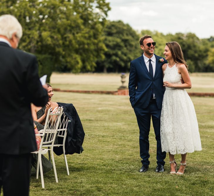 Bride and groom embracing during outdoor wedding speeches