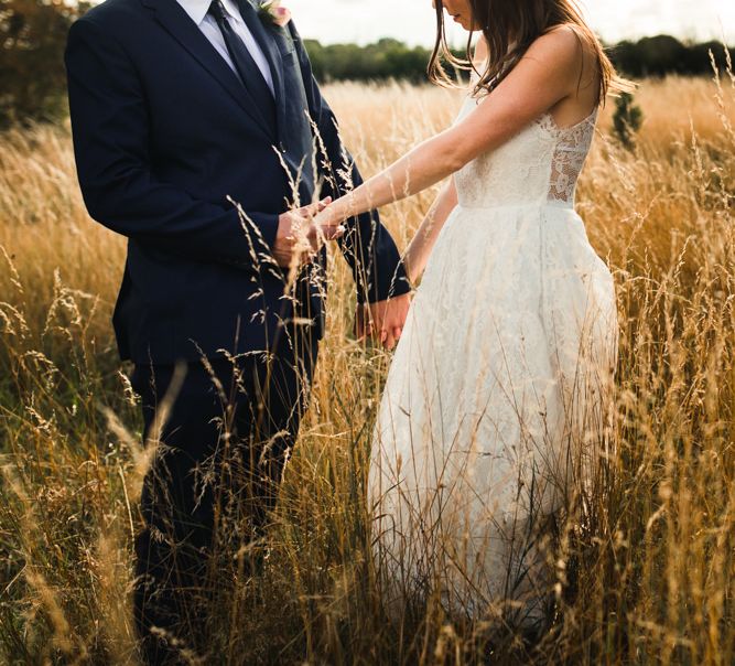 Bride and groom walking through the fields