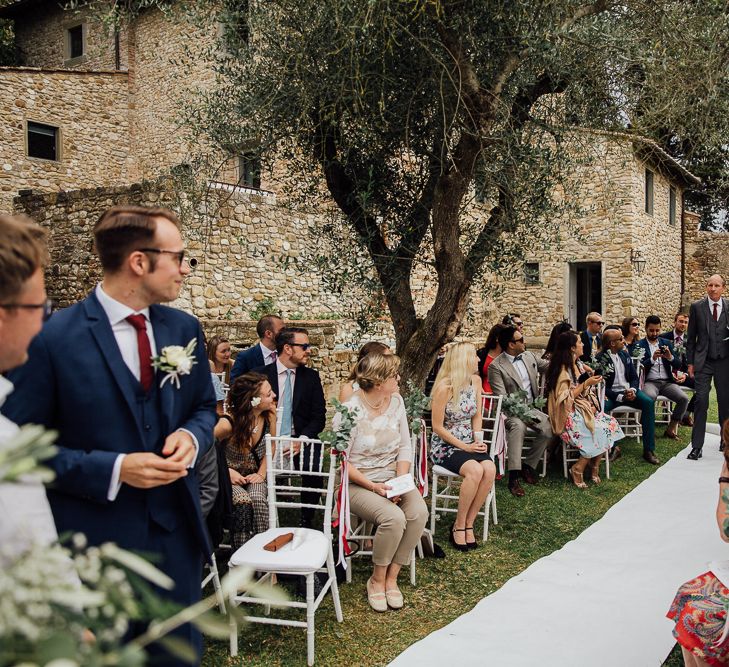 Outdoor ceremony in the Castle grounds. Destination wedding in Italy. Featuring RMW The List recommended suppliers Wiskow &amp; White and Red on Blonde. Rue de Seine wedding gown with deep red chianti bridesmaid Rewritten dresses.