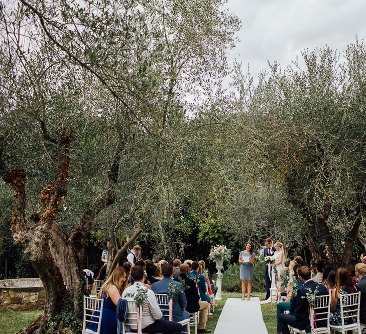 Ceremony in  Castle gardens. . Destination wedding in Italy. Featuring RMW The List recommended suppliers Wiskow &amp; White and Red on Blonde. Rue de Seine wedding gown with deep red chianti bridesmaid Rewritten dresses.