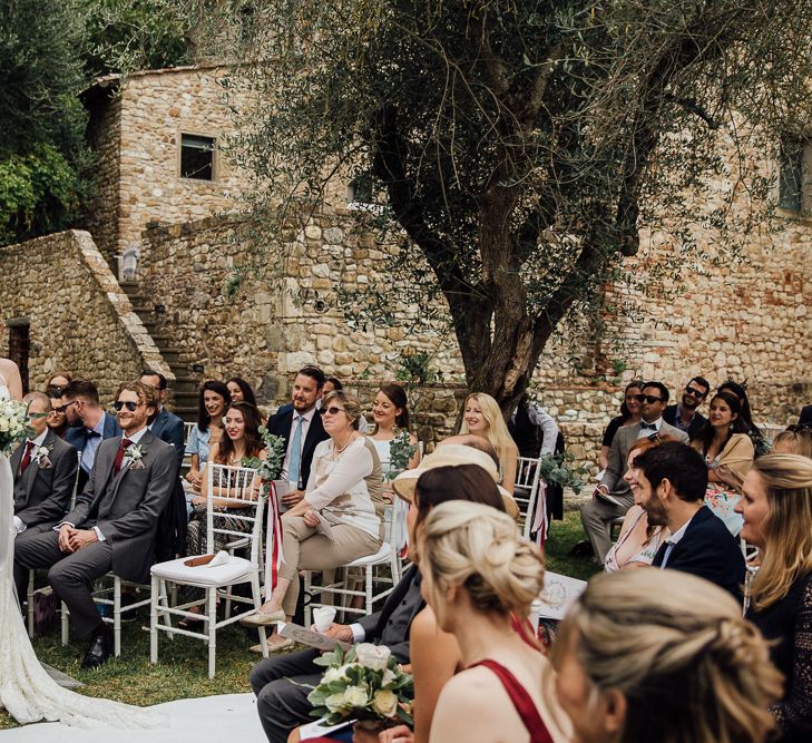 Ceremony in  Castle gardens. .Destination wedding in Italy. Featuring RMW The List recommended suppliers Wiskow &amp; White and Red on Blonde. Rue de Seine wedding gown with deep red chianti bridesmaid Rewritten dresses.