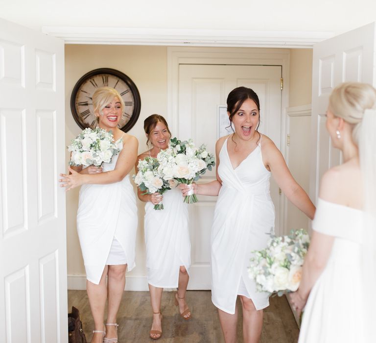 Bridesmaids in white dresses first look