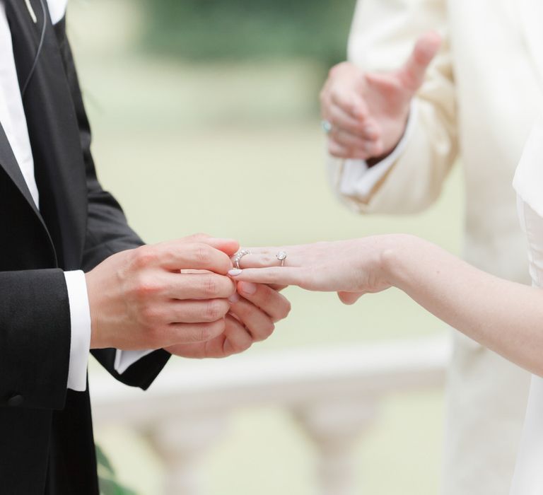 Groom putting on the wedding ring during the ceremony