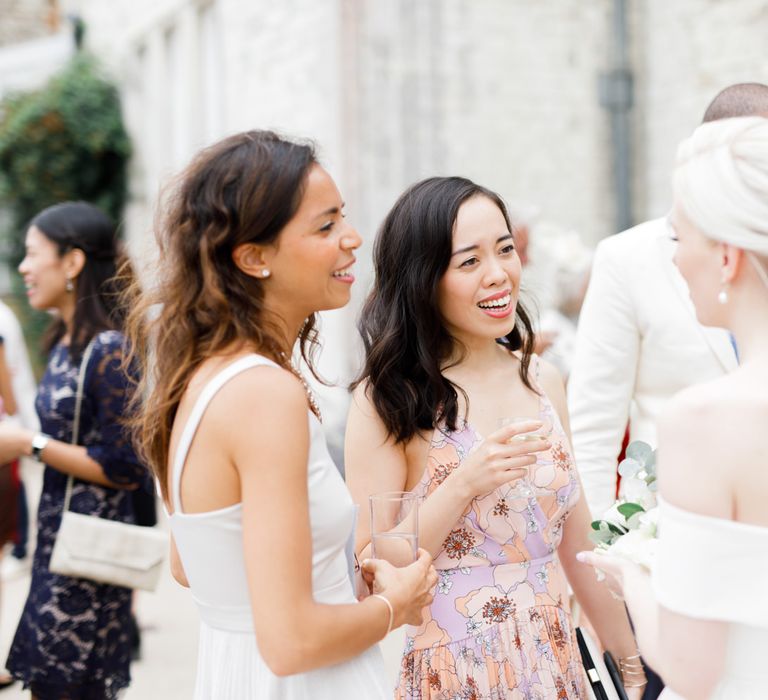 Bride in off the shoulder wedding dress talking to wedding guests