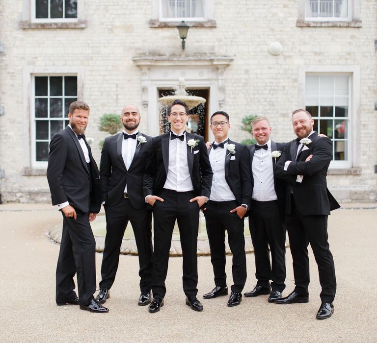 Groomsmen in tuxedos and bow ties at Froyle Park