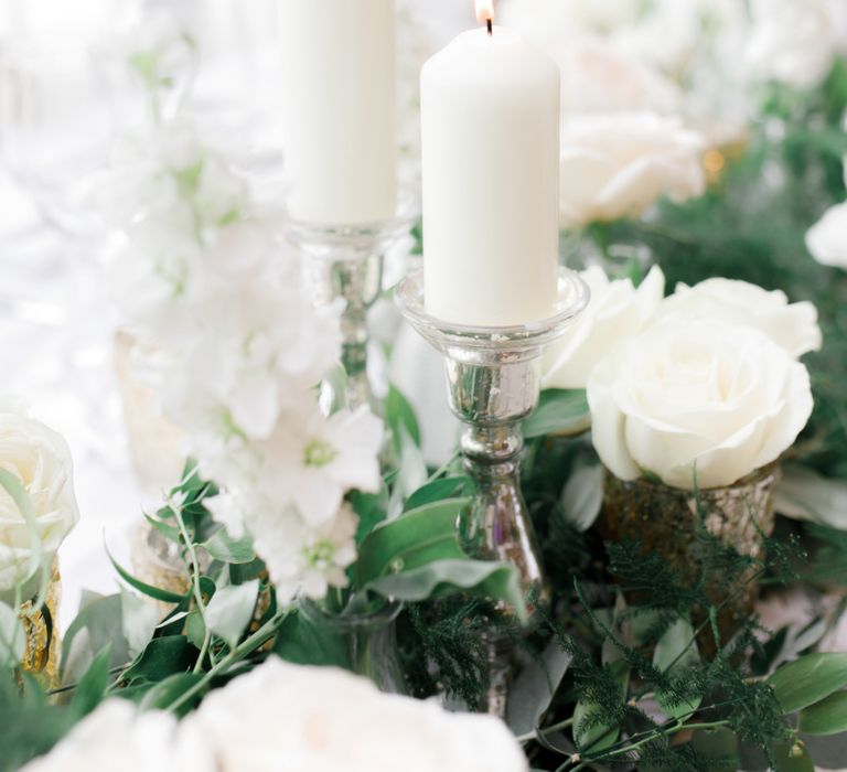 White candles on silver candle holders