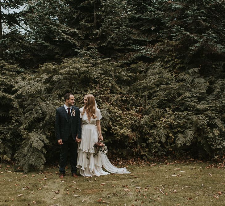 Bride in Houghton NYC Wedding Dress and Groom Check Suit holding Hands