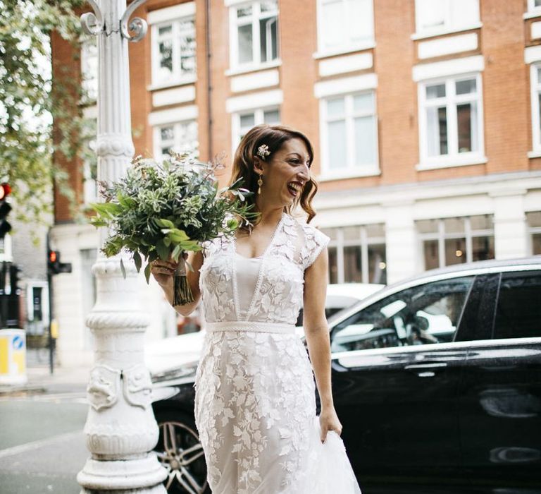 Bride wearing Phase Eight Wedding Dress teamed with hair accessory and white foliage bouquet