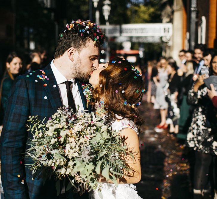 Bride and groom confetti shot at autumn celebration in London with green and white foliage bouquet