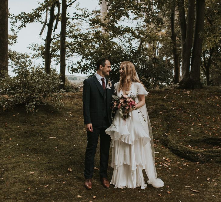 Bride in Tiered Houghton NYC Wedding Dress and Groom in Check House of Fraser Suit in a Forest