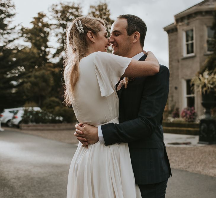 Bride in Tiered Houghton NYC Wedding Dress and Groom in Check House of Fraser Suit  Embracing