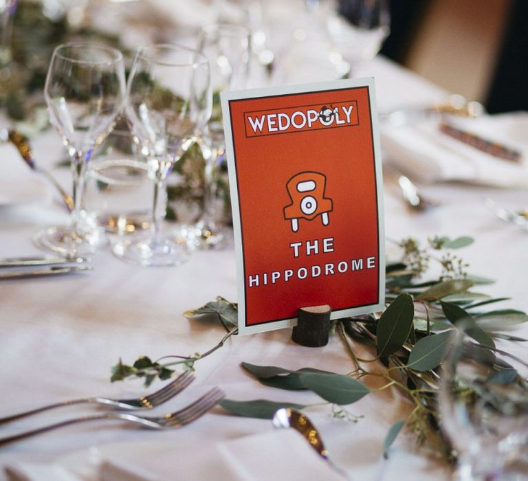 Monopoly style table setting names for London reception with foliage decor